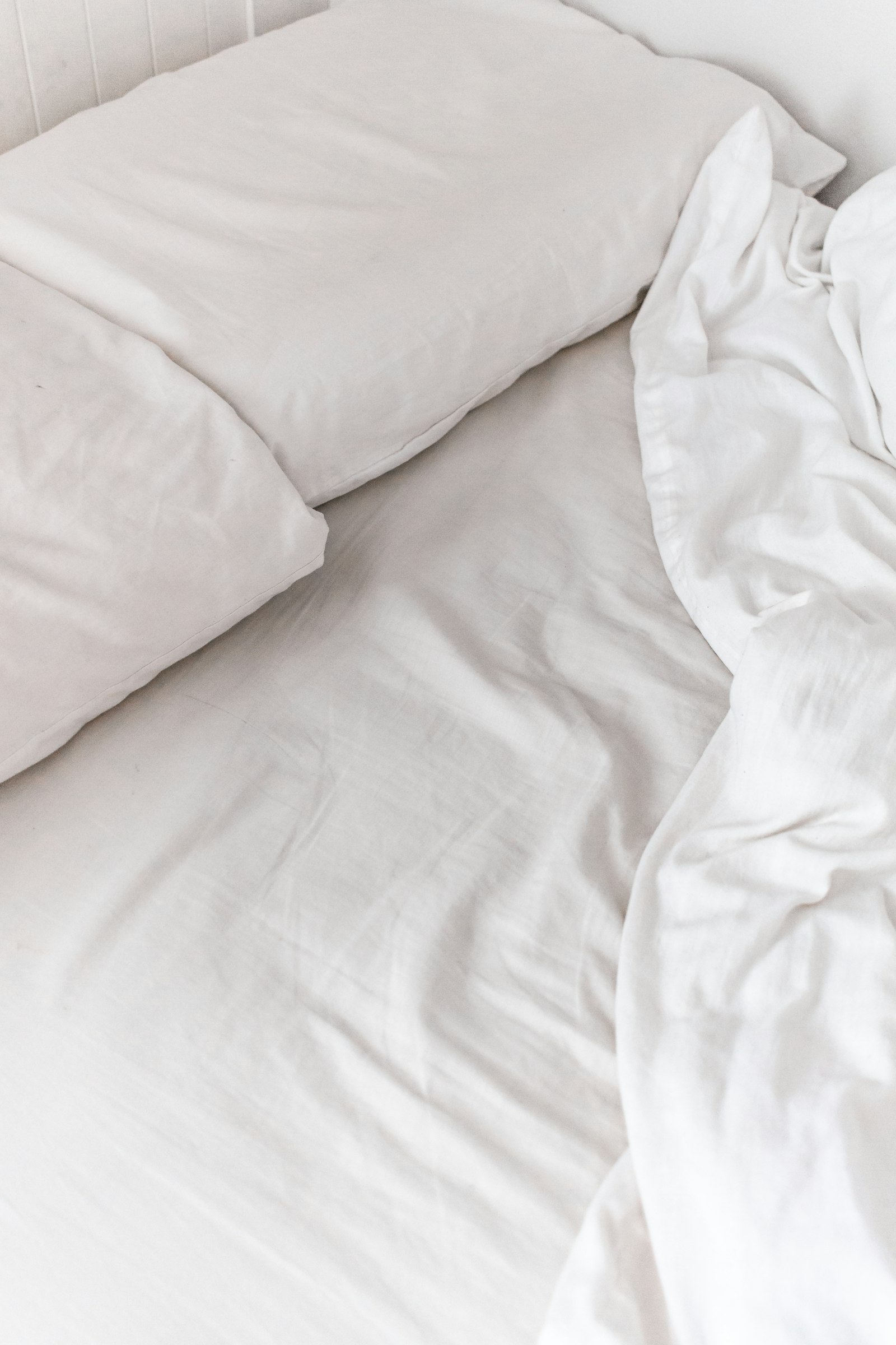 Crisp white sheets on an unmade bed