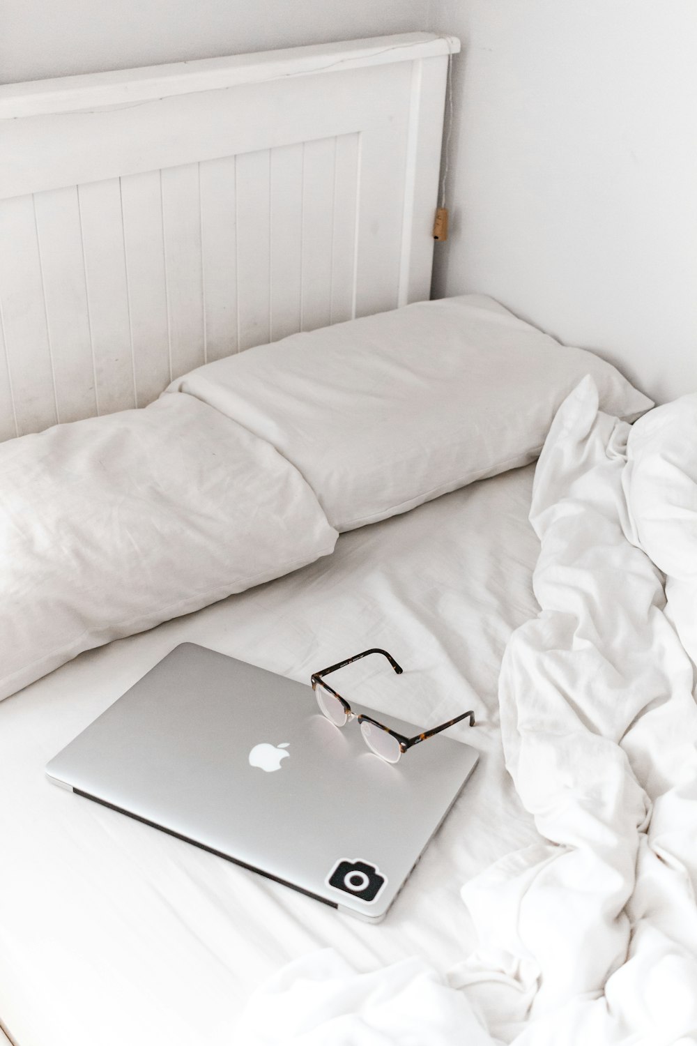 silver macbook on white bed