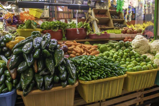 A vibrant market stall displaying fresh fruits and vegetables with dark green and yellow accents.