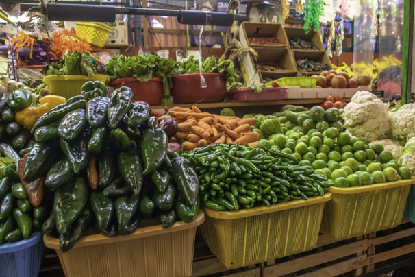 A vibrant market stall displaying fresh fruits and vegetables with dark green and yellow accents.