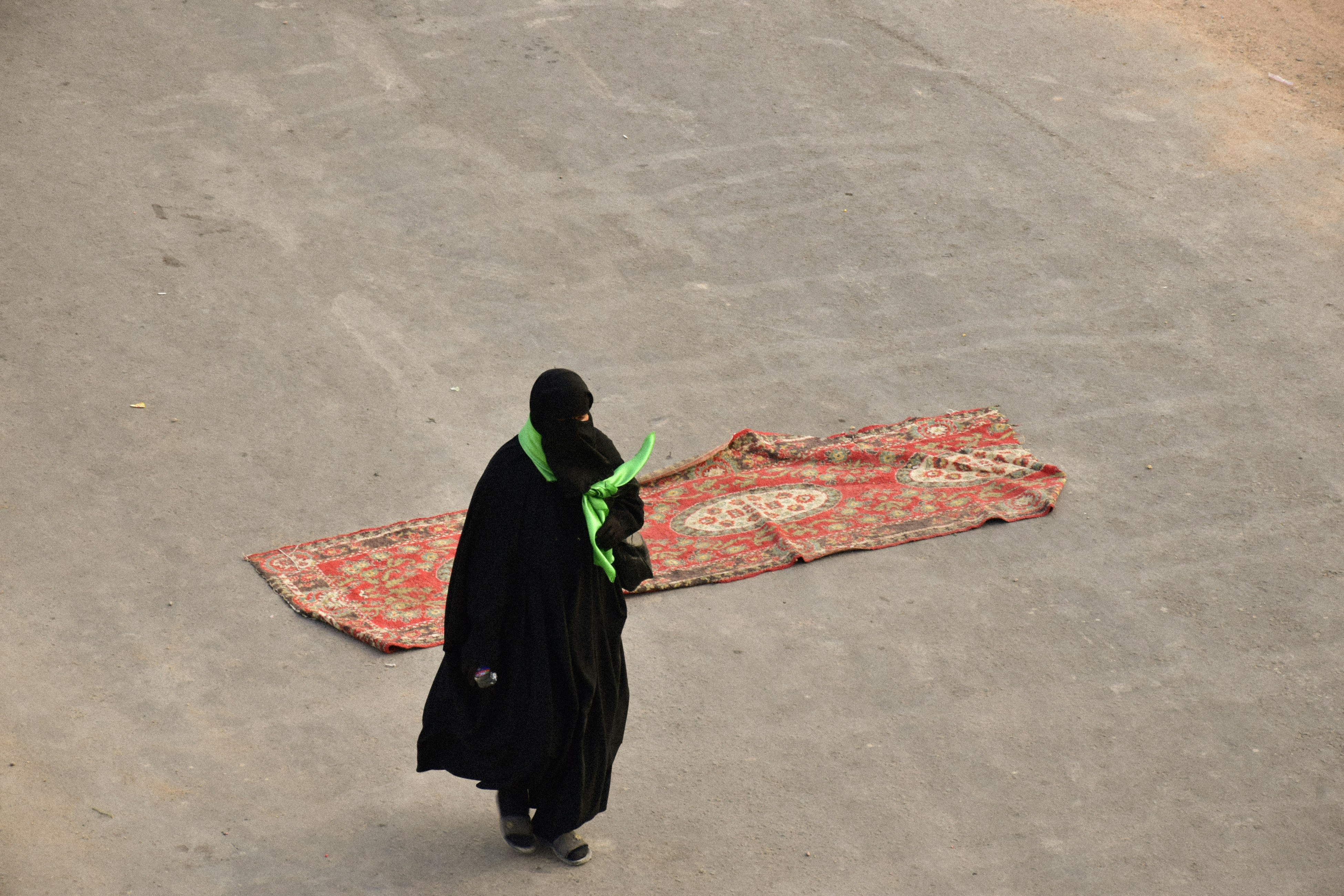 woman in black hijab standing on gray concrete floor