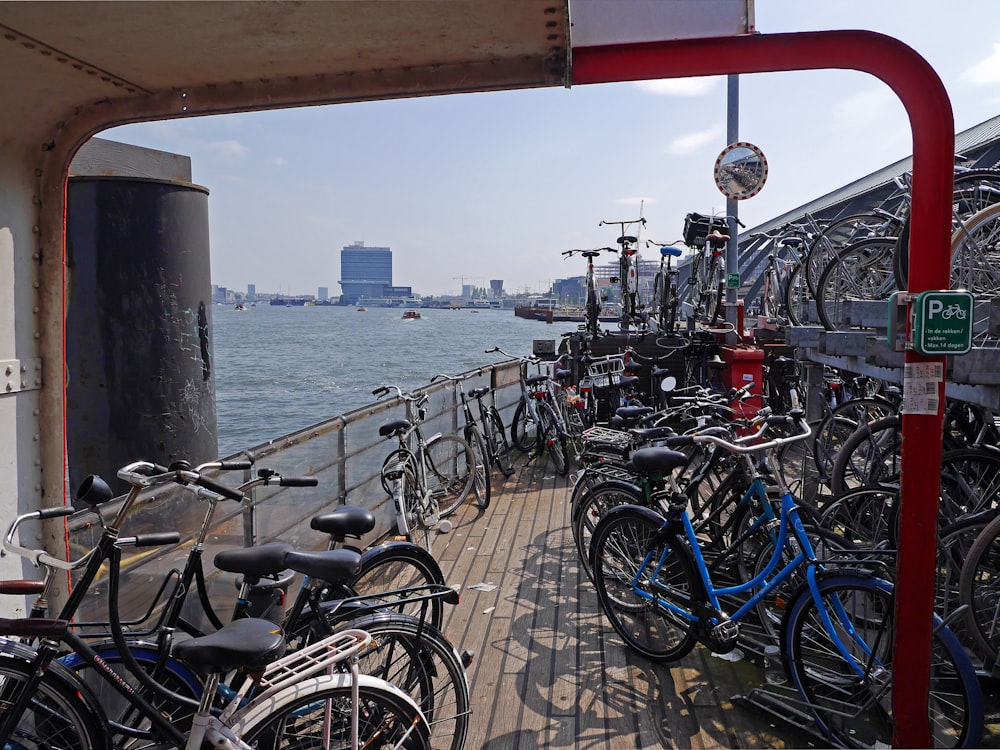 bicycles parked beside railings near body of water during daytime