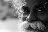 A black and white photograph of an elderly man with expressive eyes.