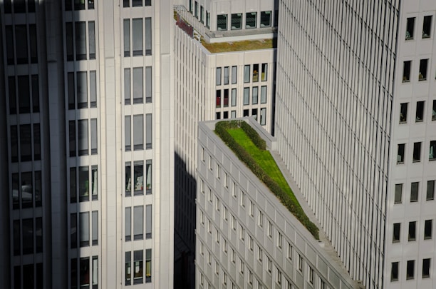 Futuristic mixed-use building with solar panels and green rooftop garden.