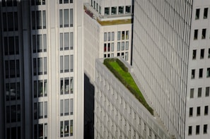 A modern mixed-use building with green rooftop gardens in an urban setting.