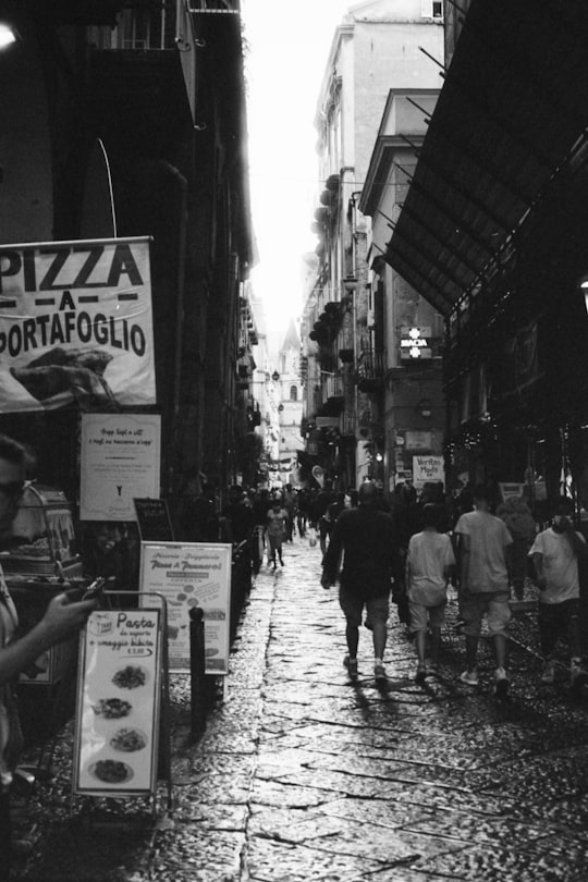 grayscale photo of people walking on street in Napoli Italy