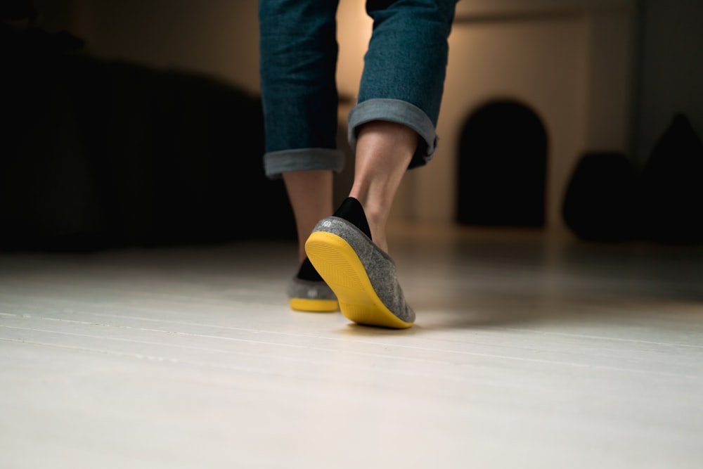 person in blue denim jeans and yellow and blue socks