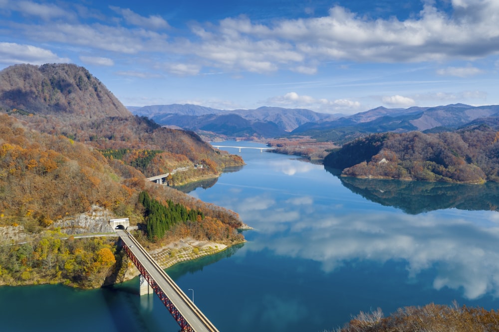 green lake surrounded by mountains under blue sky during daytime