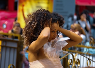 woman in white dress holding her hair