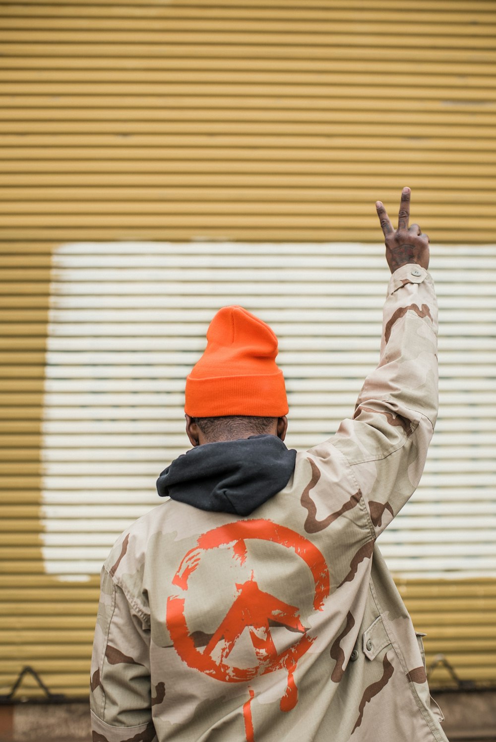 man in red knit cap raising his right hand