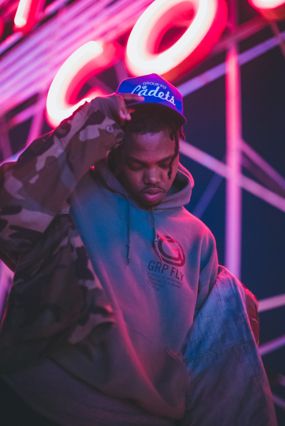 homme en sweat à capuche bleu portant une casquette bleue et rouge