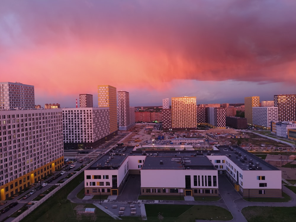 Stadtgebäude unter orangefarbenem Himmel bei Sonnenuntergang