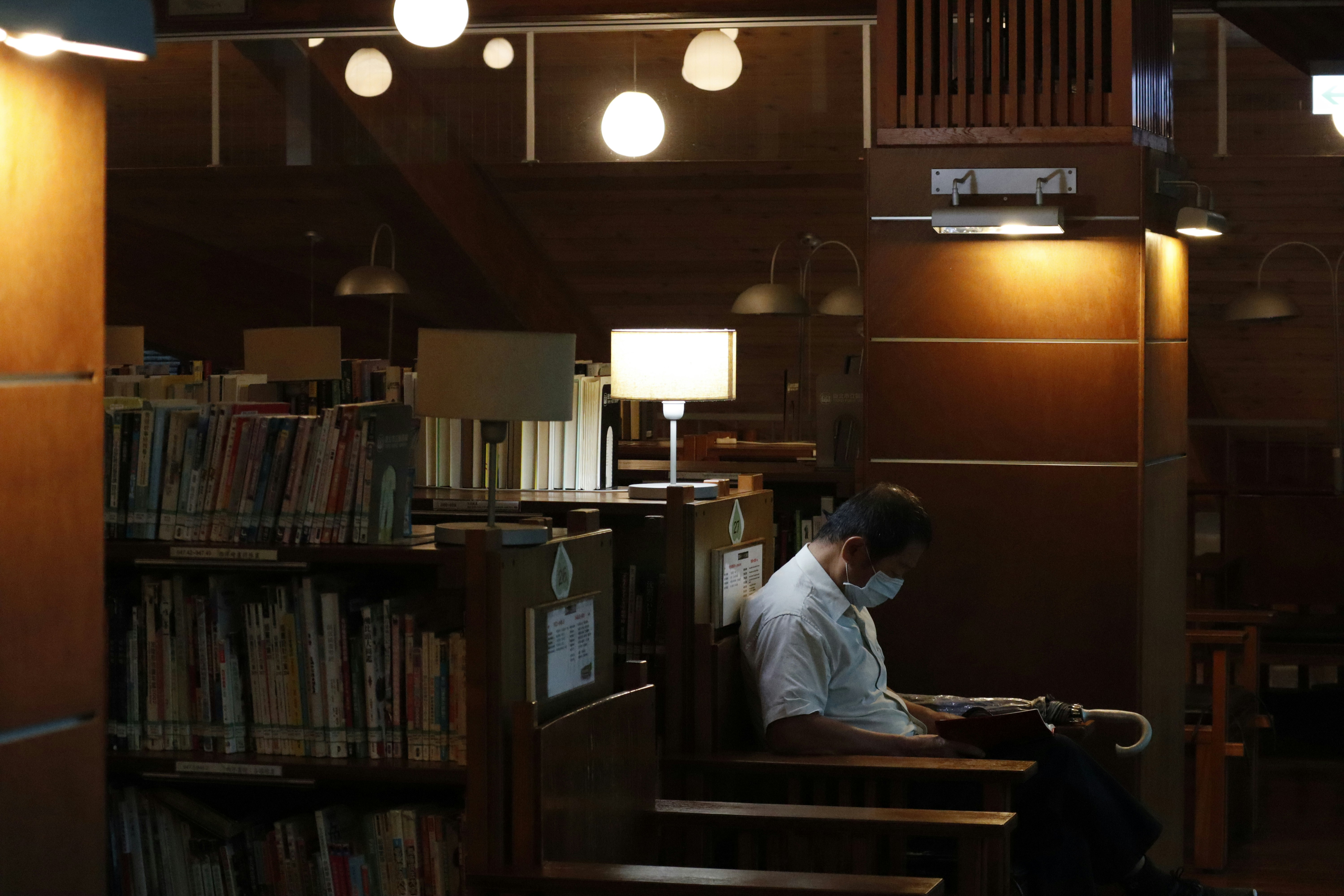 Man studying in a chair in a dim library