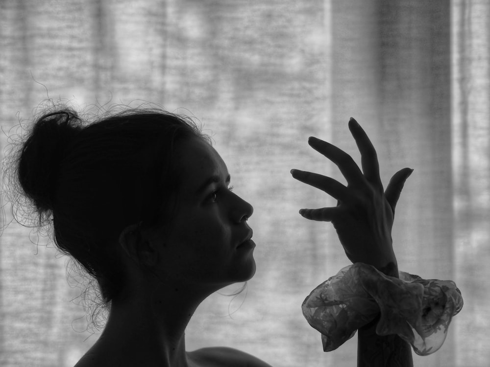 grayscale photo of woman with hand on face