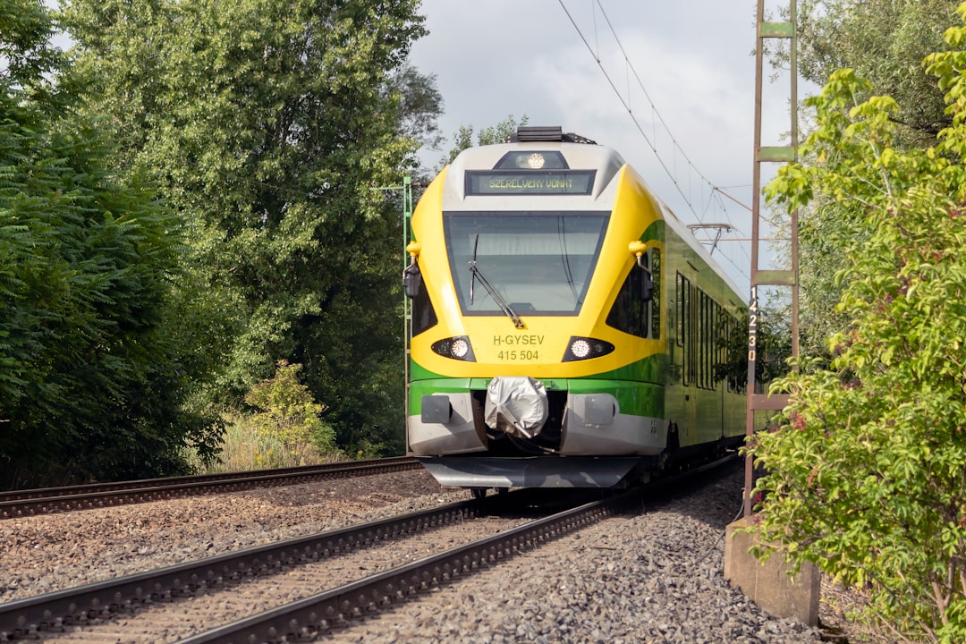 yellow and gray train on rail tracks,
