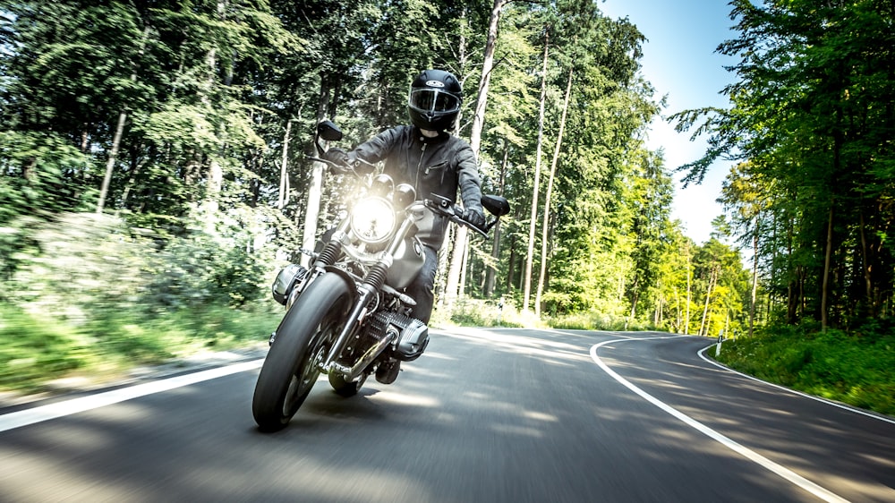 man in black helmet riding motorcycle on road during daytime