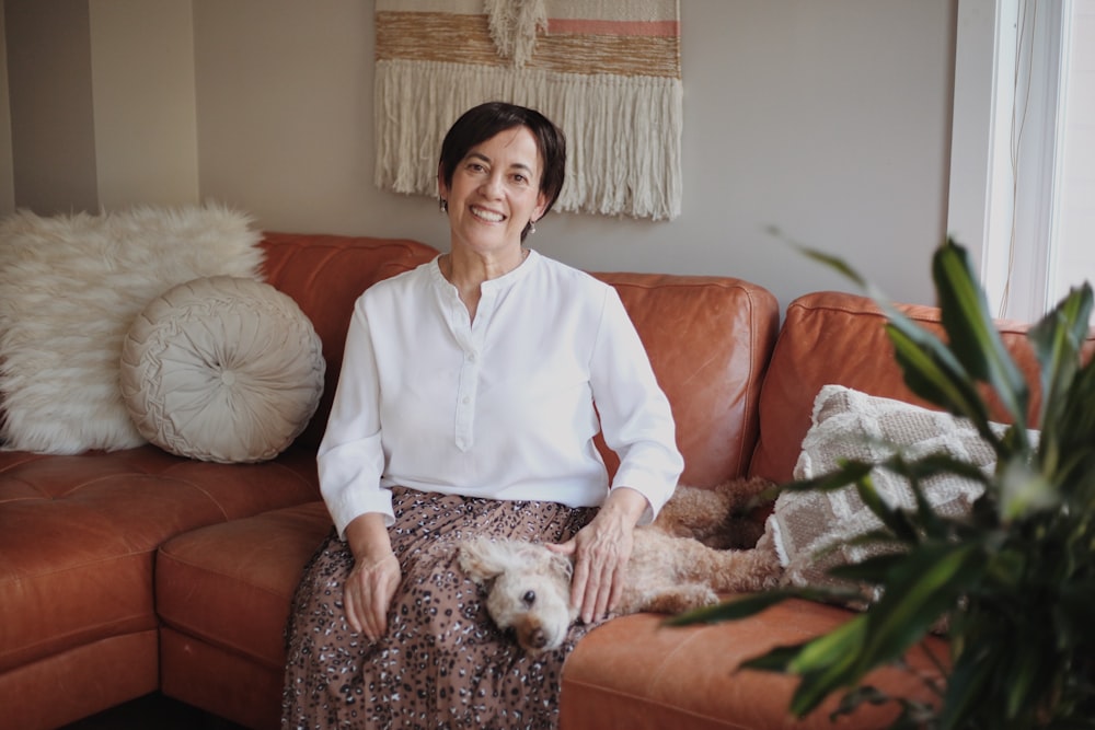 woman in blue dress shirt sitting on orange couch