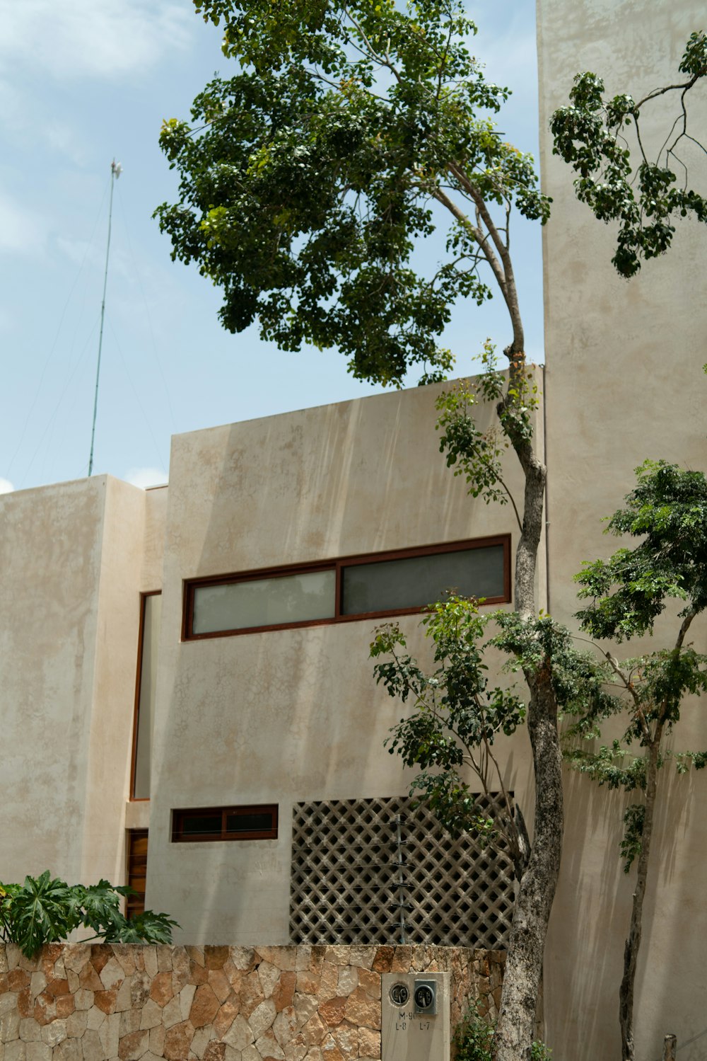 beige concrete building with green trees
