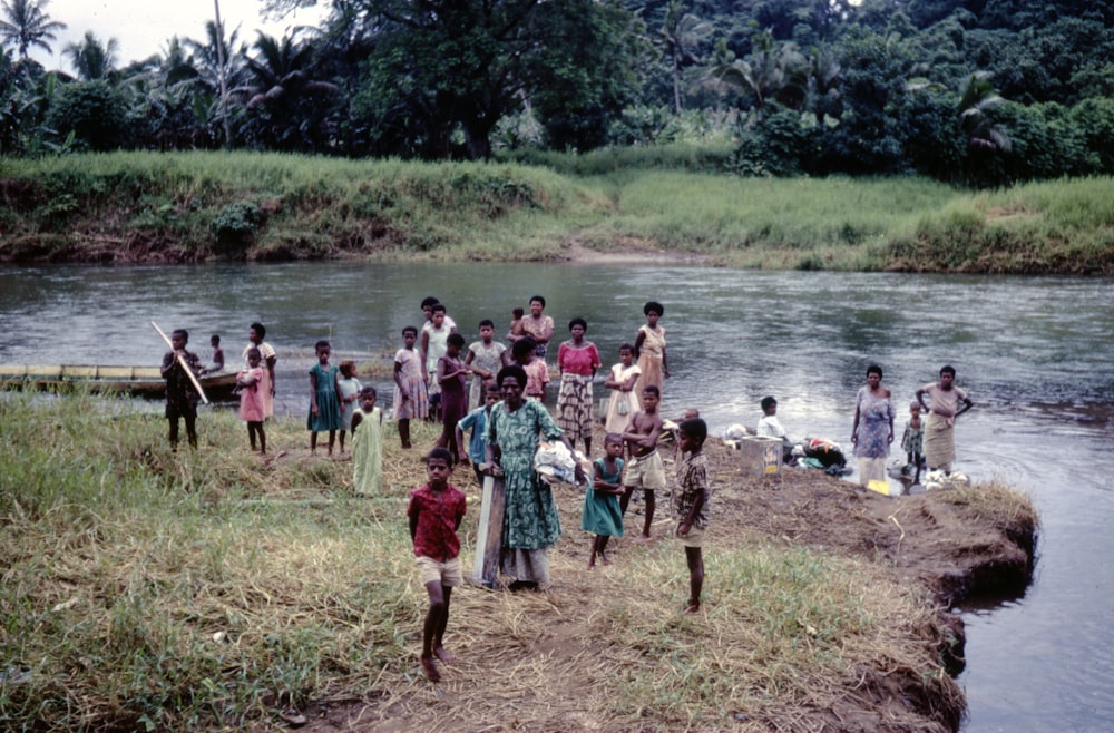 a group of people standing next to a river