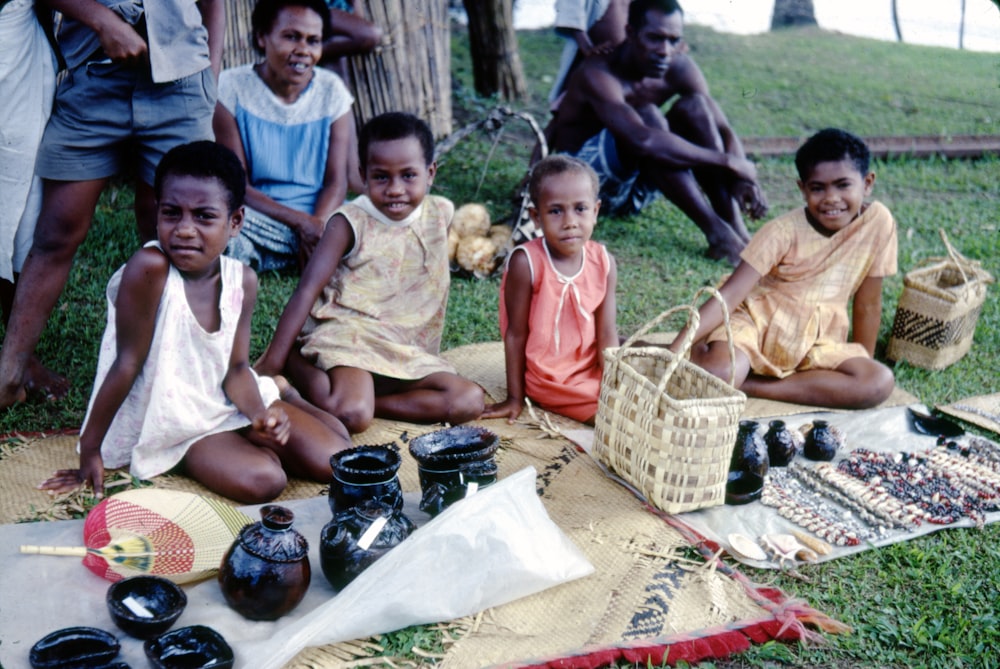 group of people sitting on brown woven mat