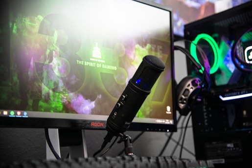 black microphone beside black flat screen computer monitor