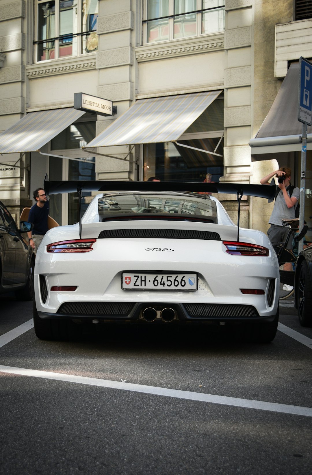 white bmw m 3 parked in front of white building