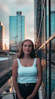 woman in blue tank top standing near black metal railings during daytime