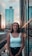 woman in blue tank top standing near black metal railings during daytime