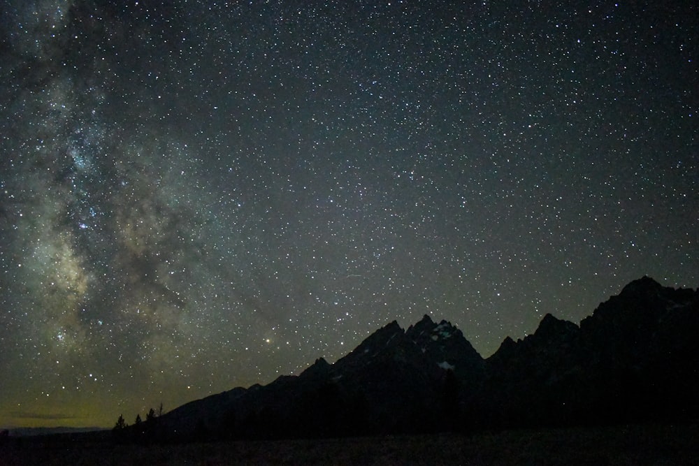 silhouette of mountain under starry night