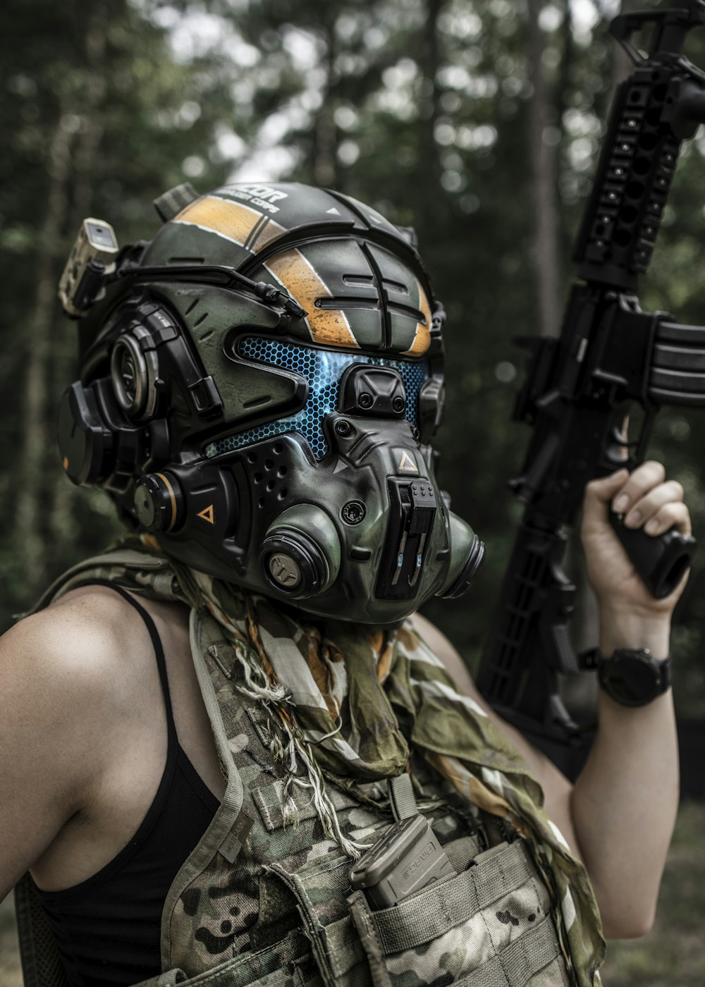 woman in black and brown camouflage tank top holding black rifle