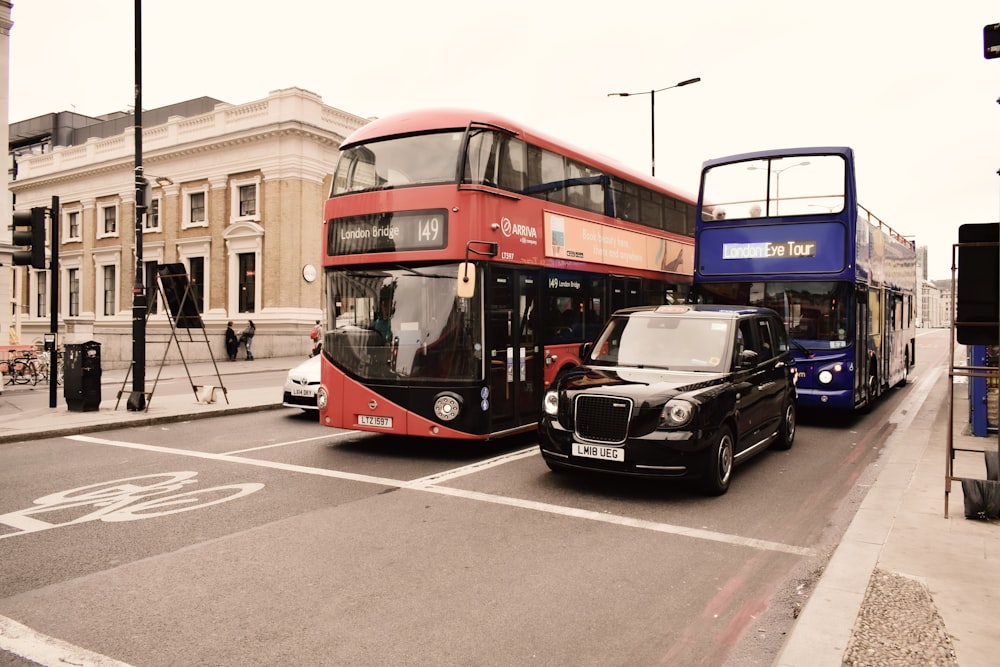 Autobús negro y rojo en la carretera cerca del autobús rojo durante el día