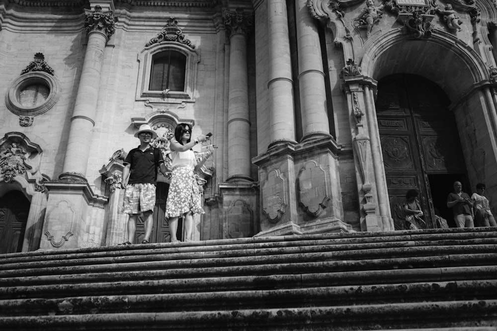 grayscale photo of couple standing on stairs