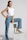 woman in white tank top and blue denim jeans sitting on white chair