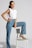 woman in white tank top and blue denim jeans sitting on white chair