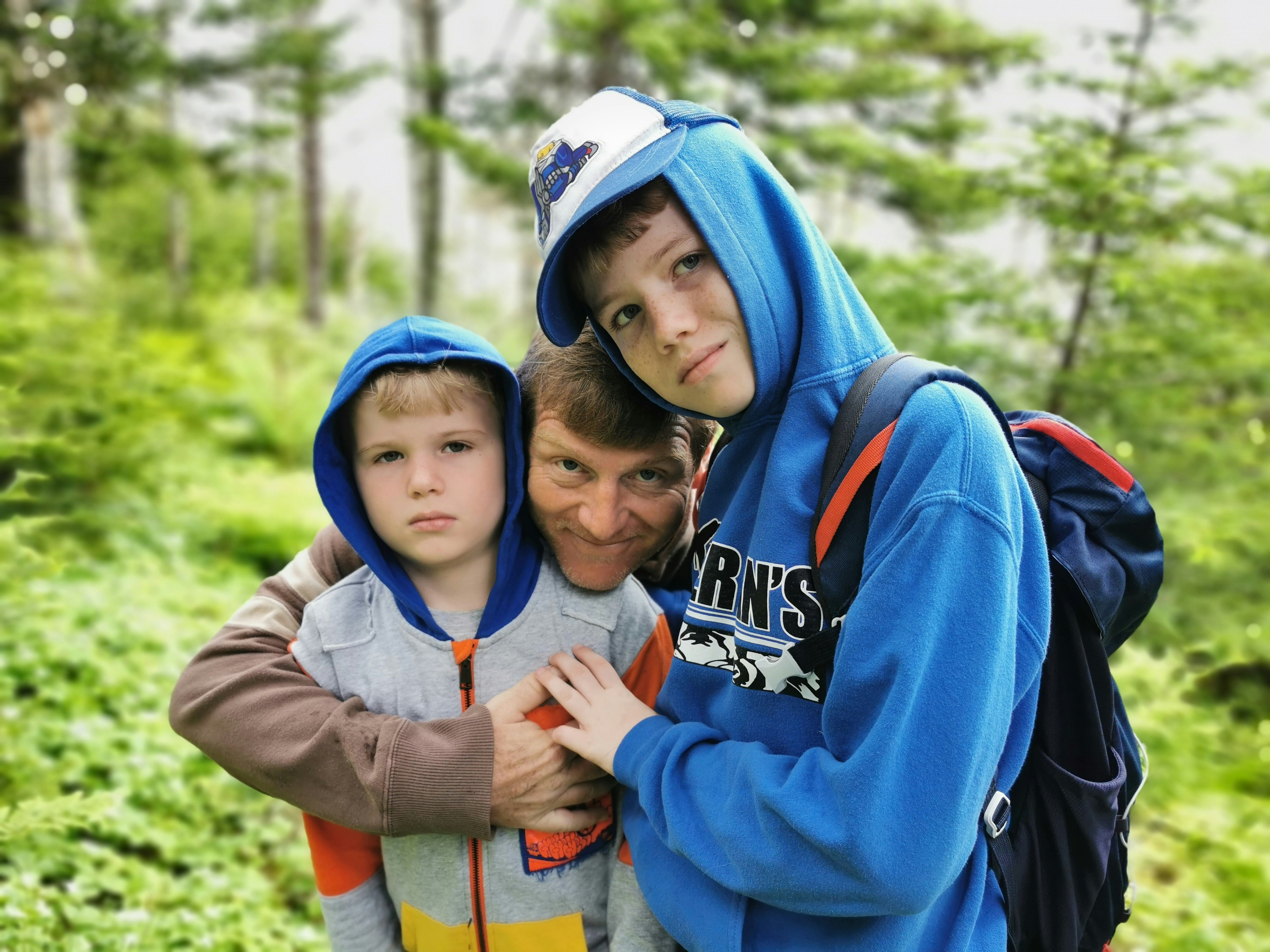 woman in blue hoodie carrying girl in blue hoodie