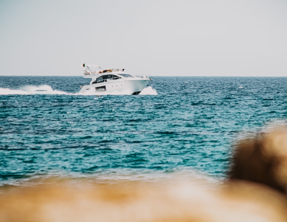 weißes und schwarzes Boot tagsüber auf See