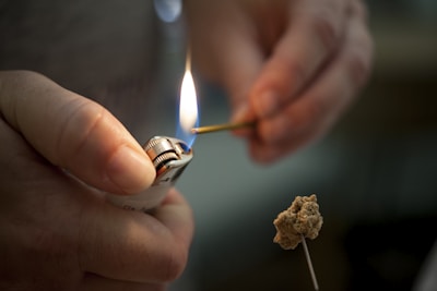 person holding lighted lighter with fire