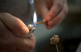 person holding lighted lighter with fire