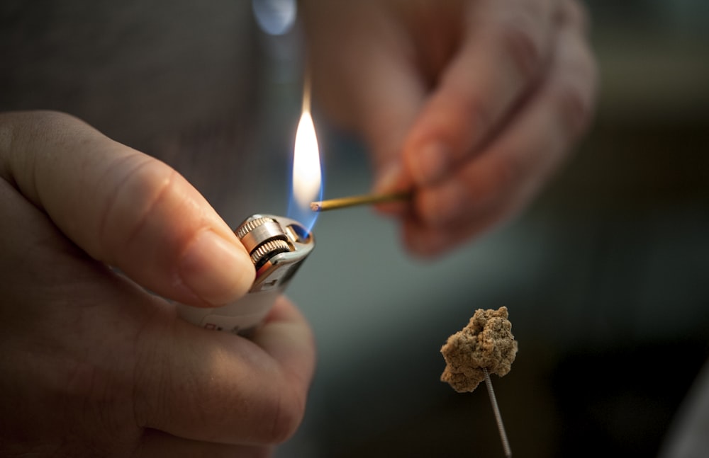 person holding lighted lighter with fire