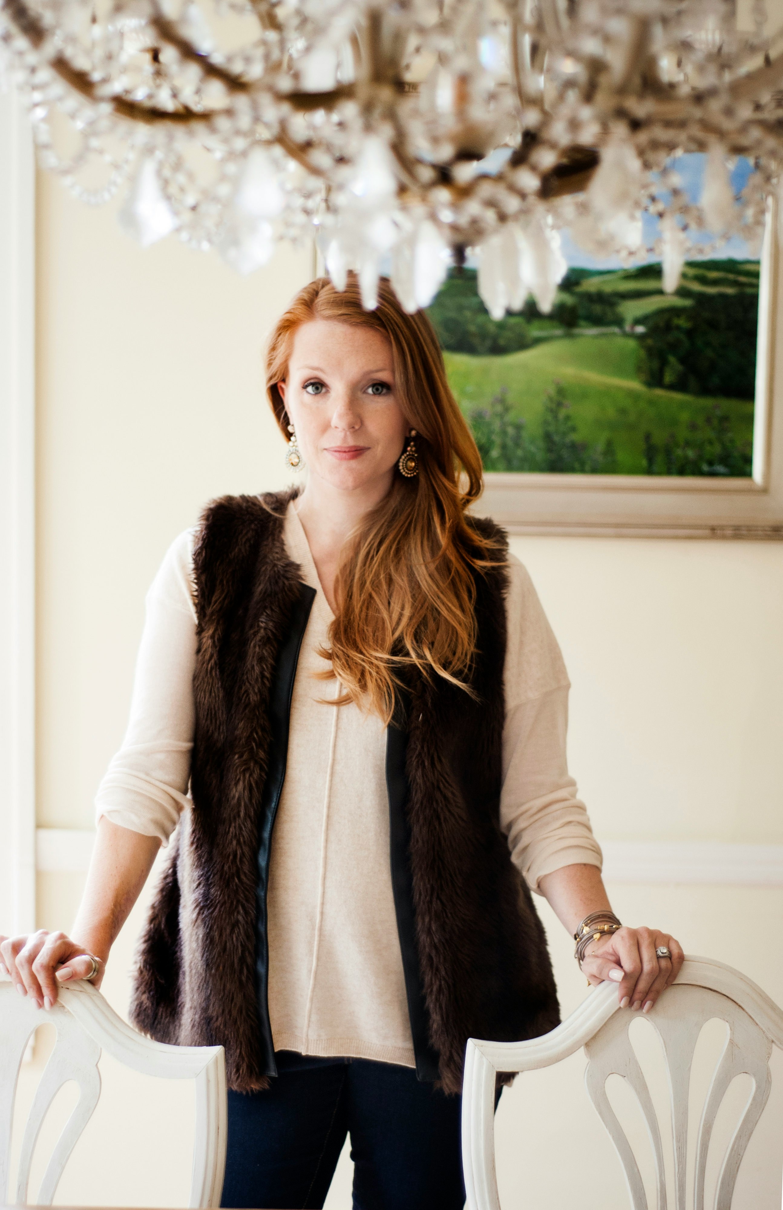 woman in brown fur coat standing near white wall