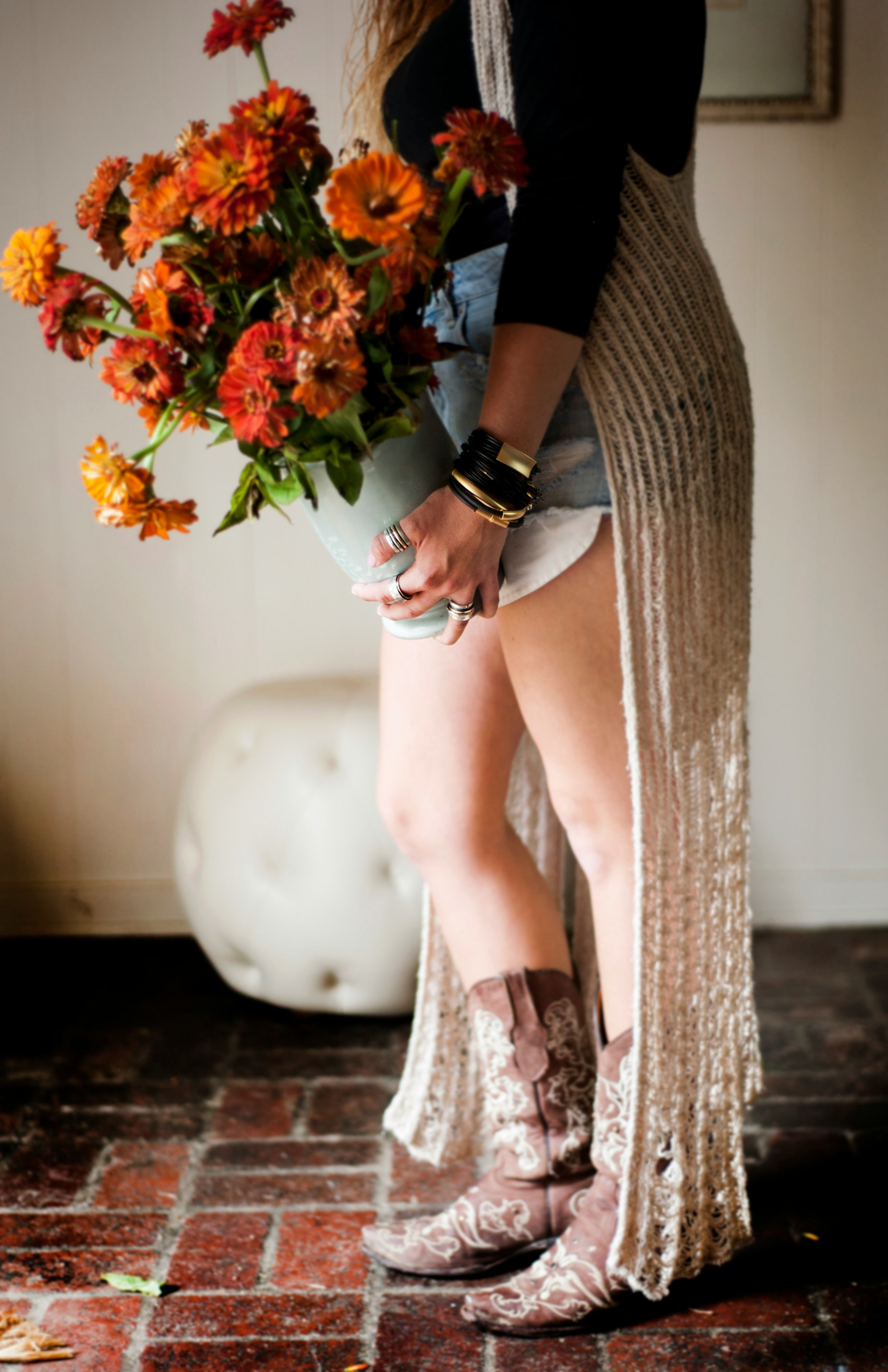 woman in black dress holding red flowers