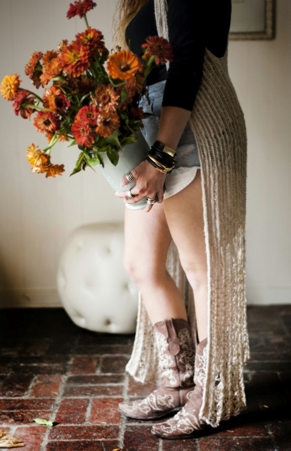 Femme en robe noire tenant des fleurs rouges