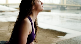 woman in black tank top sitting on concrete floor during daytime