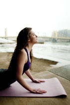 A peaceful scene of a woman practicing yoga outdoors at sunrise.