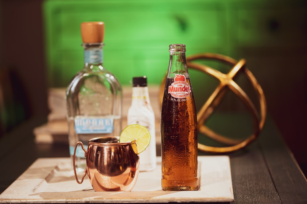 clear glass bottle beside clear glass cup