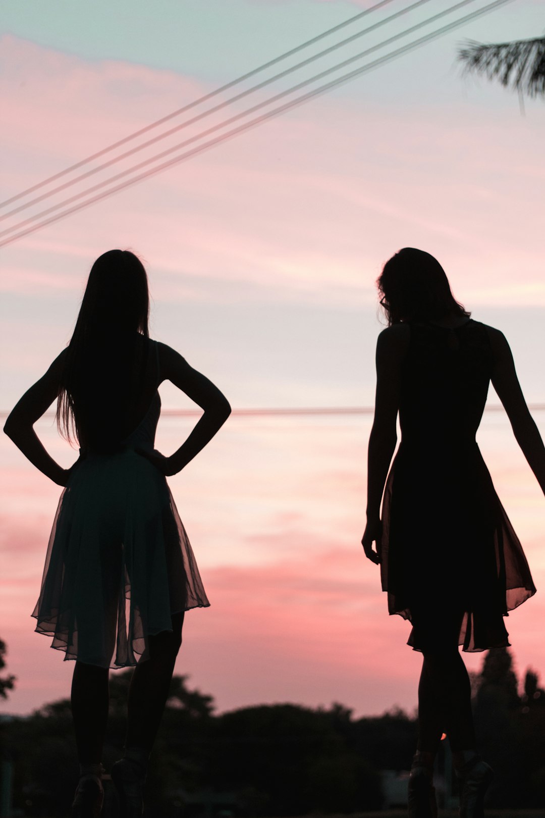 2 women in dress standing on beach during sunset