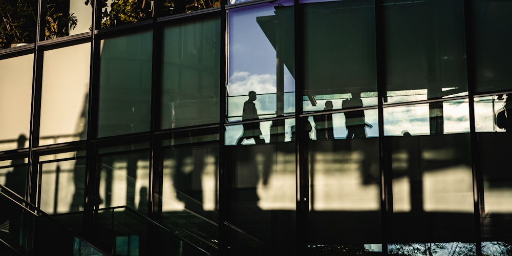 man in black jacket standing in front of glass window