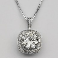Delicate diamond pendant catching the light as it hangs from a fine silver chain.