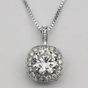 Graceful neckpiece with fine silver detailing and brilliant diamonds displayed on an ivory fabric