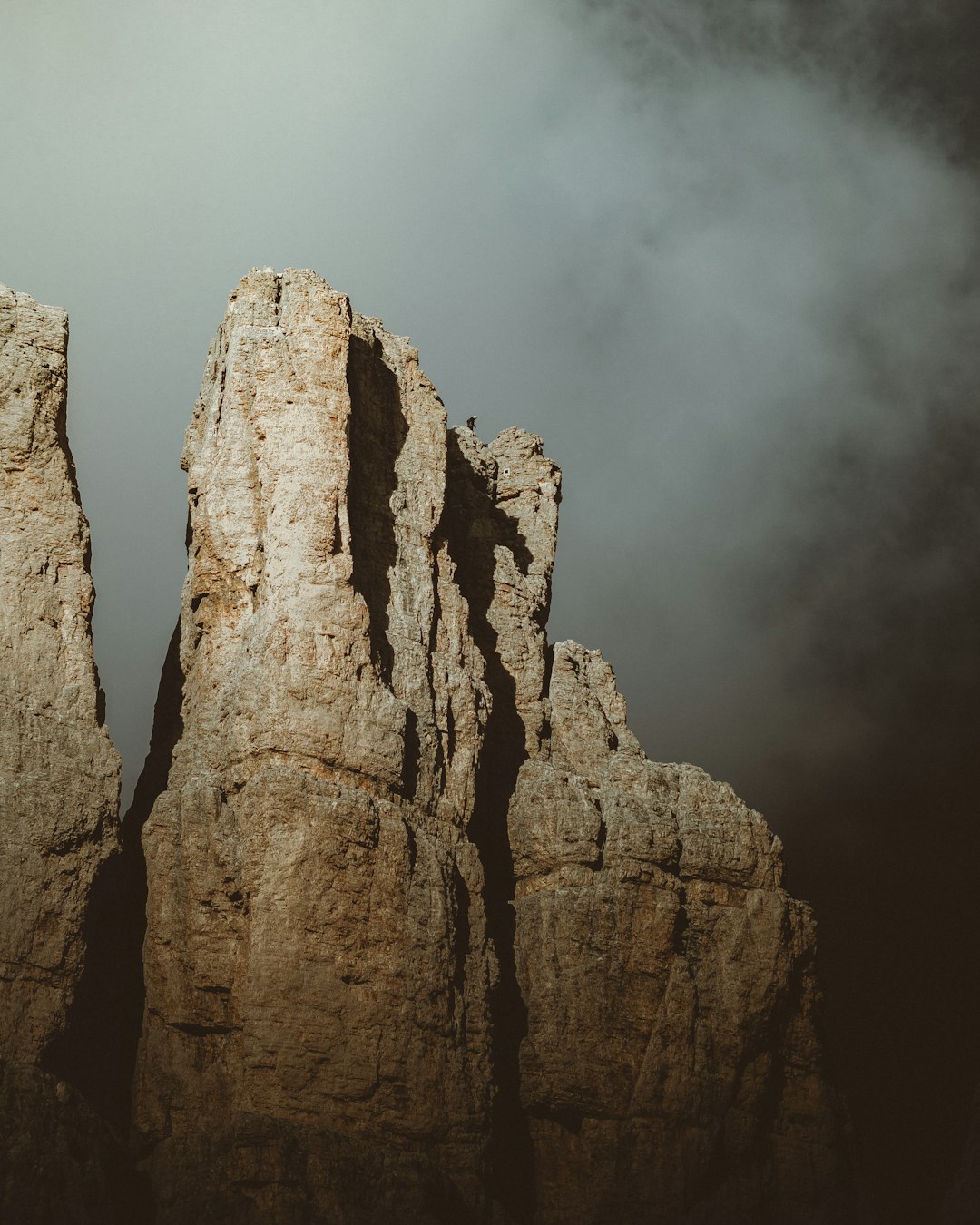 brown rock formation under white clouds